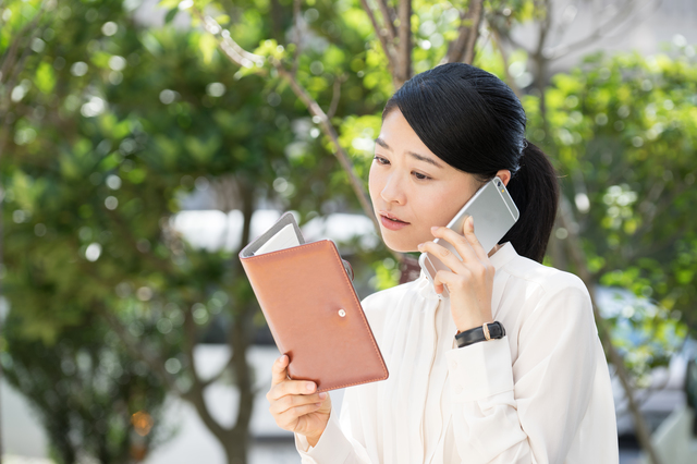 電話予約をしている女性